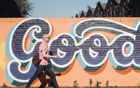 man walking beside graffiti wall