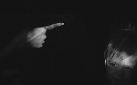 grayscale photo of girl holding her chin