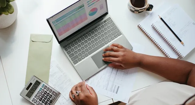a person sitting at a table with a laptop